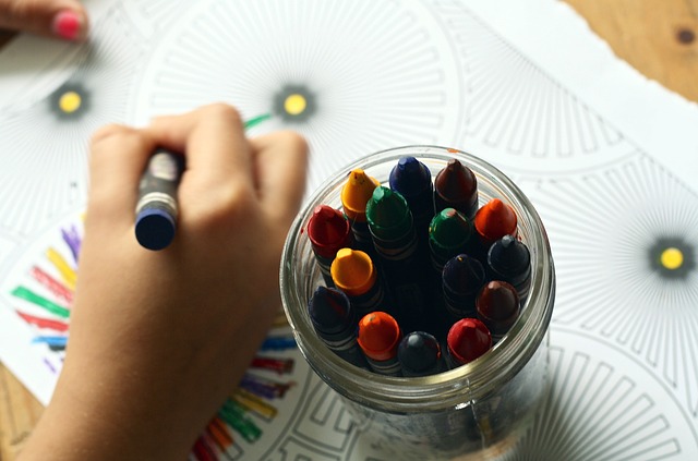 a child's hand coloring an intricate geometric coloring page