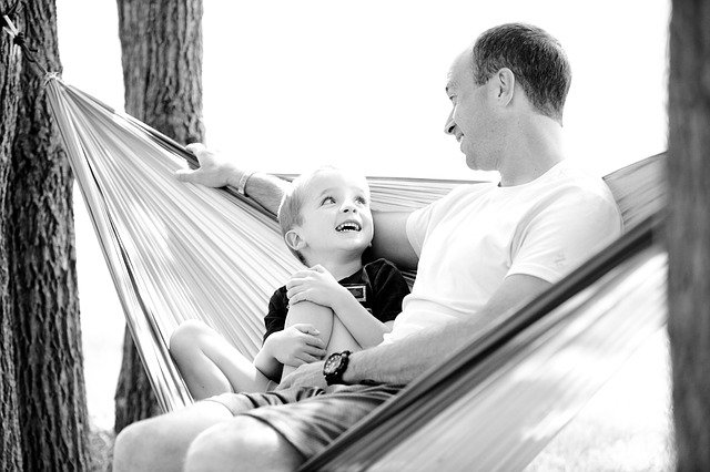 Father and son sitting on a hammock together
