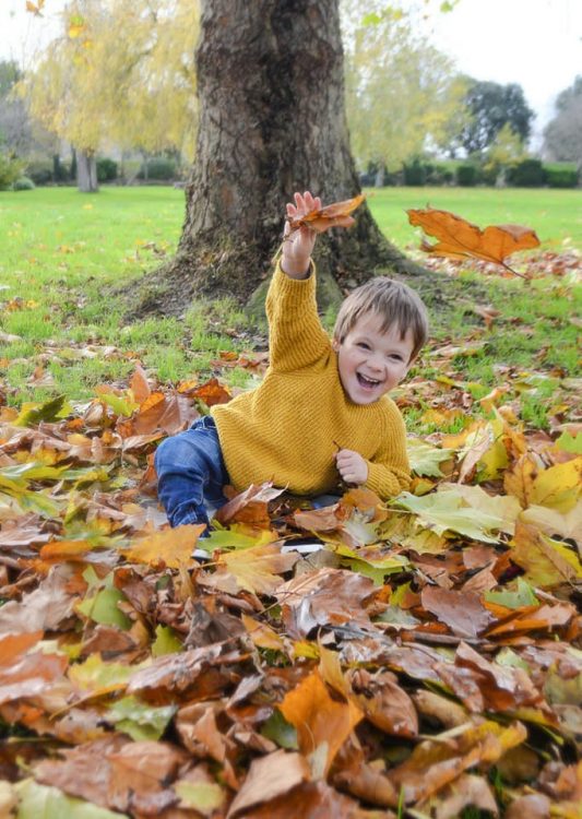 Noah Pedlar sits on a bed of leaves in a park