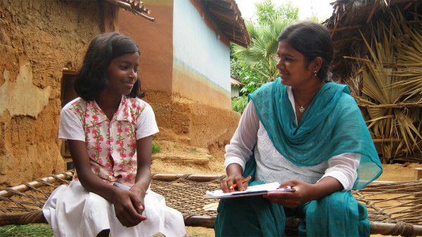 A teacher tutors a student in India