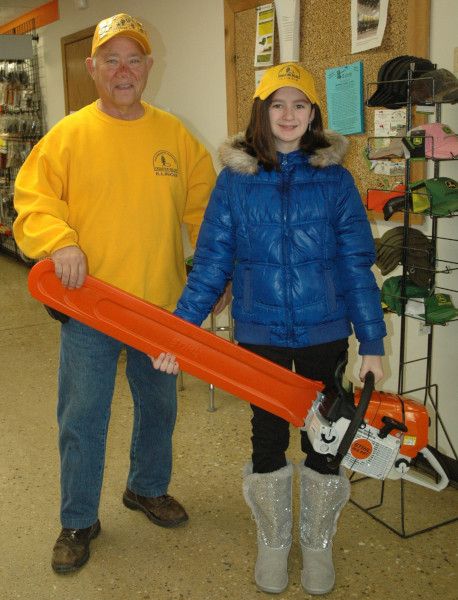 Lily holds the chainsaw that she helped purchase for mission trips!